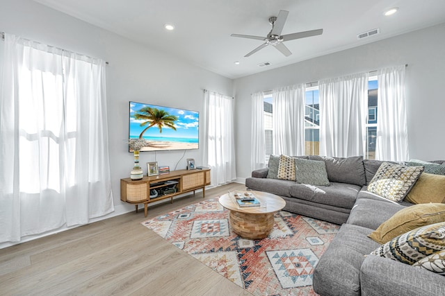 living room with ceiling fan and light wood-type flooring