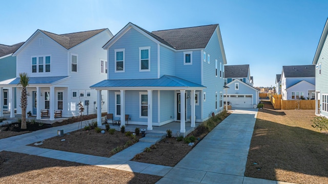 view of front of home with a front yard, a garage, a porch, and an outdoor structure