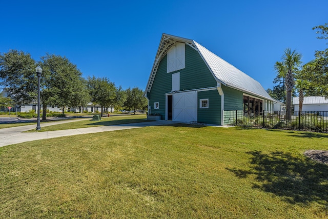 view of property exterior with a lawn and an outdoor structure