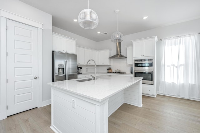 kitchen featuring sink, white cabinetry, appliances with stainless steel finishes, and an island with sink