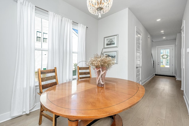 dining area featuring light wood-type flooring and an inviting chandelier