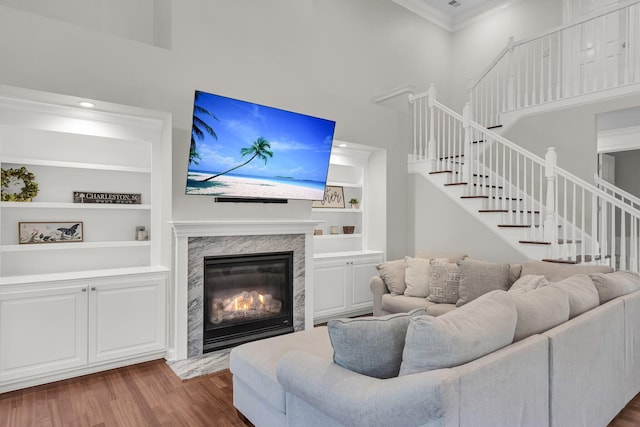 2720 Oak Manor Dr, Mount Pleasant, SC 29466 - living room with a towering ceiling, crown molding, wood finished floors, built in shelves, and stairs
