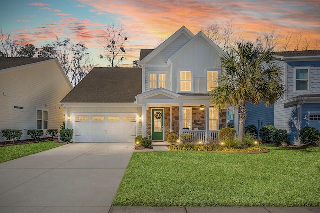 view of front of property with covered porch, a garage, and a yard