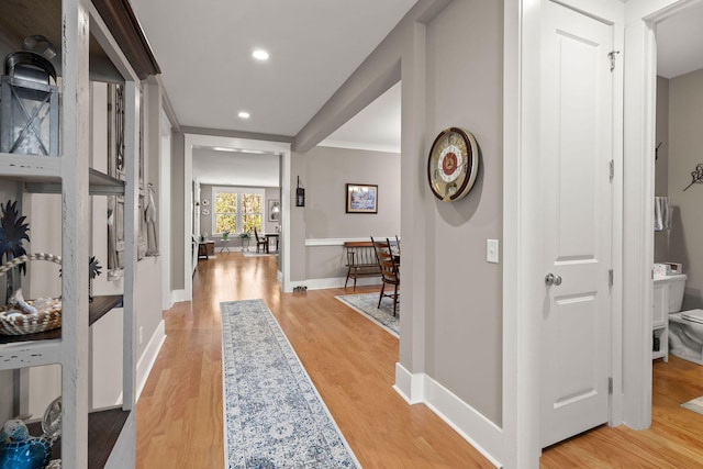 hallway featuring light hardwood / wood-style flooring and ornamental molding