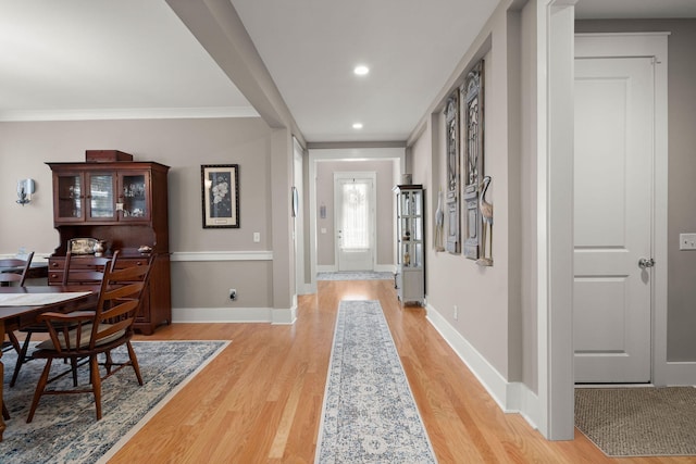 foyer entrance featuring crown molding and light hardwood / wood-style flooring