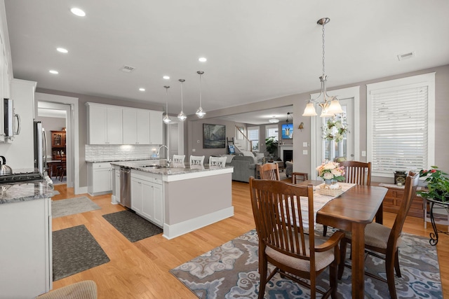 kitchen with pendant lighting, white cabinetry, appliances with stainless steel finishes, and decorative backsplash