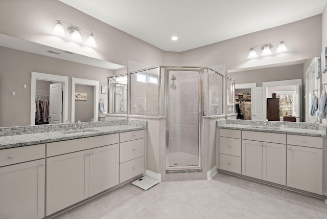 bathroom featuring a shower with door, tile patterned floors, and vanity