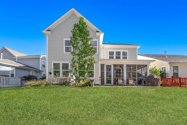 rear view of house with a sunroom and a lawn