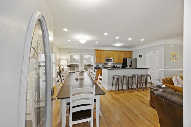 dining room featuring light hardwood / wood-style flooring and ornamental molding