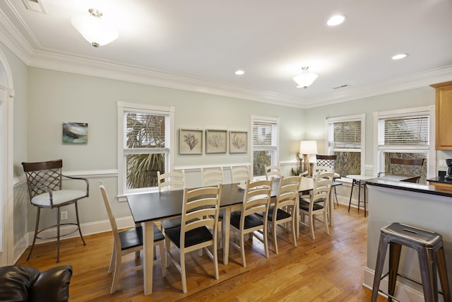 dining room with crown molding and light wood-type flooring