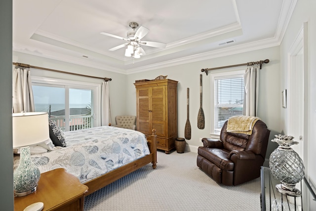 bedroom with access to exterior, a tray ceiling, light colored carpet, and ceiling fan