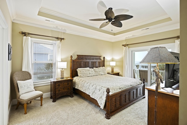 carpeted bedroom with ceiling fan, ornamental molding, and a raised ceiling