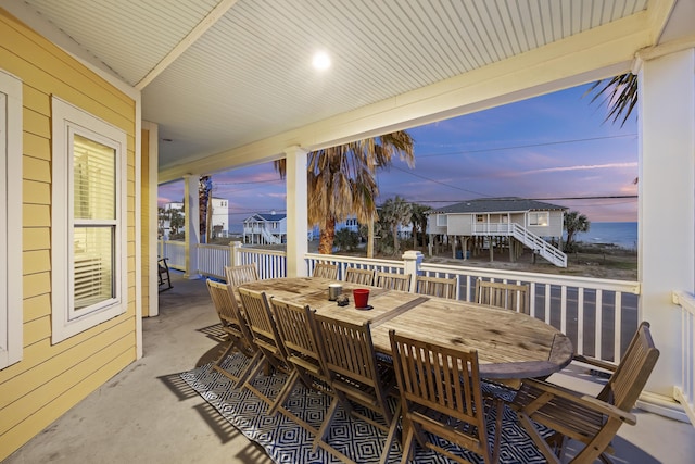 patio terrace at dusk featuring a water view