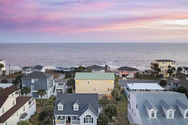 aerial view at dusk featuring a water view