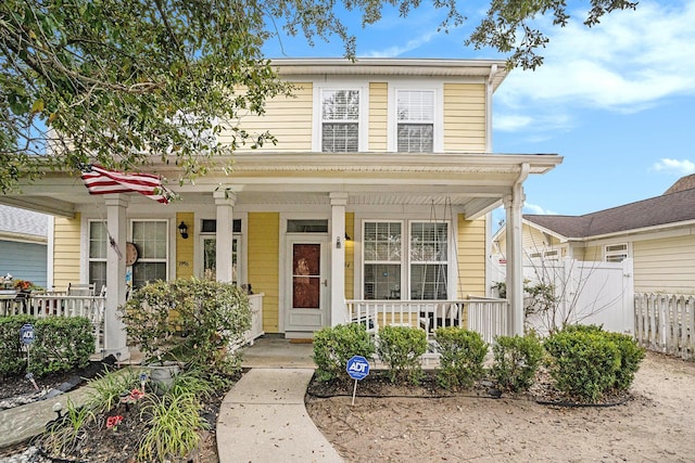 view of front of house featuring fence and a porch