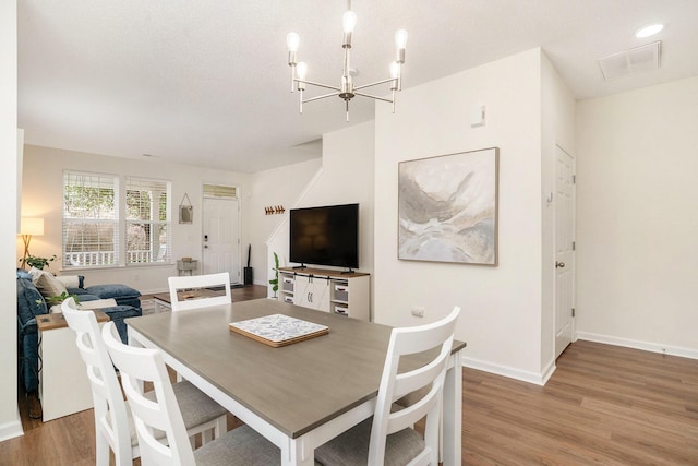 dining area with recessed lighting, visible vents, an inviting chandelier, wood finished floors, and baseboards