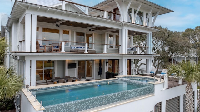 3803 Palm Blvd, Isle Of Palms, SC 29451 - back of property featuring a balcony, ceiling fan, a patio, outdoor lounge area, and a pool with connected hot tub