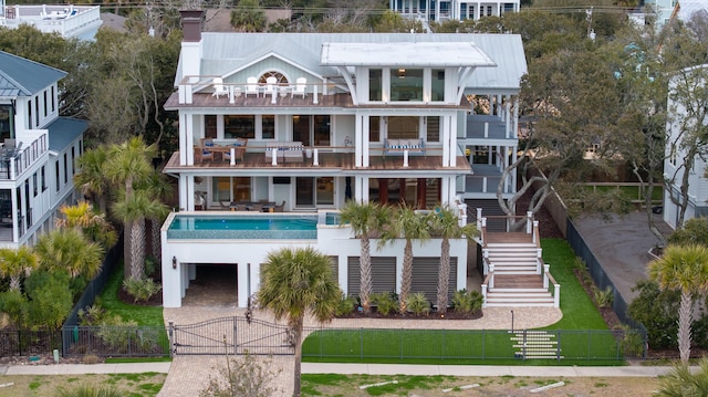 3803 Palm Blvd, Isle Of Palms, SC 29451 - rear view of property featuring a balcony, a fenced front yard, a gate, stairs, and an outdoor pool