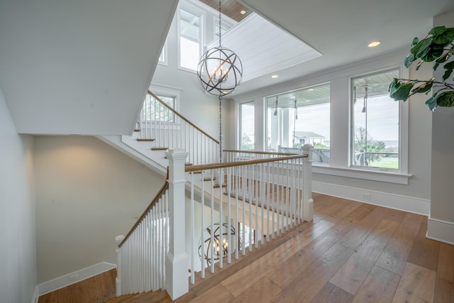 3803 Palm Blvd, Isle Of Palms, SC 29451 - staircase featuring a chandelier, plenty of natural light, baseboards, wood-type flooring, and a towering ceiling