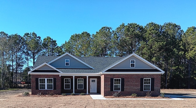 view of front of home featuring a porch and brick siding