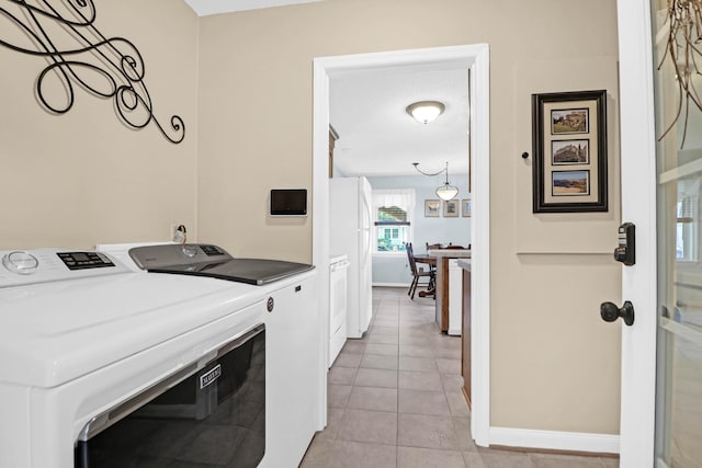 laundry area with independent washer and dryer and light tile patterned floors