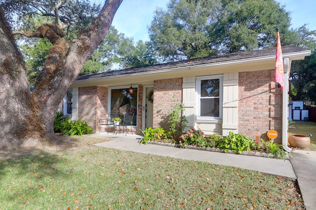 ranch-style home featuring a front lawn and a patio