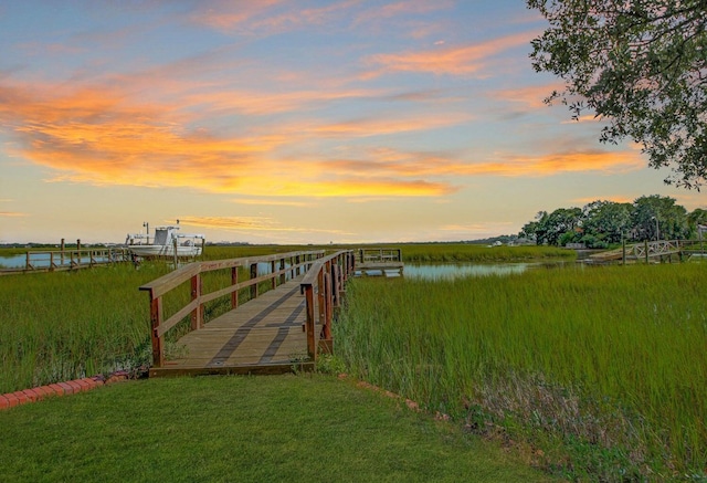 dock area featuring a lawn and a water view