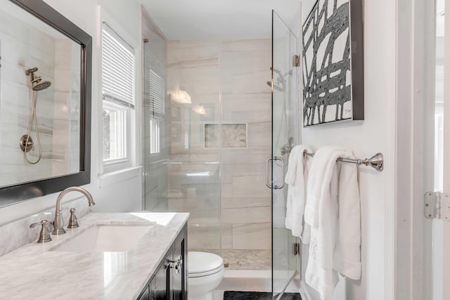 bathroom featuring a stall shower, vanity, and toilet