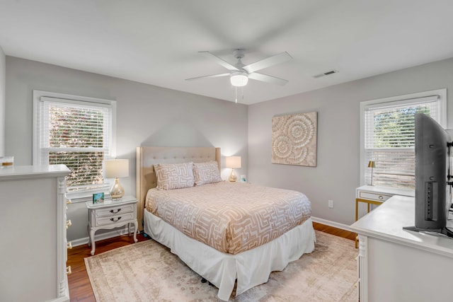 bedroom with light wood finished floors, multiple windows, and visible vents