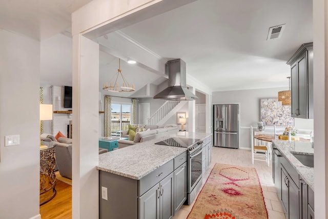 kitchen featuring stainless steel appliances, open floor plan, range hood, gray cabinets, and light stone countertops