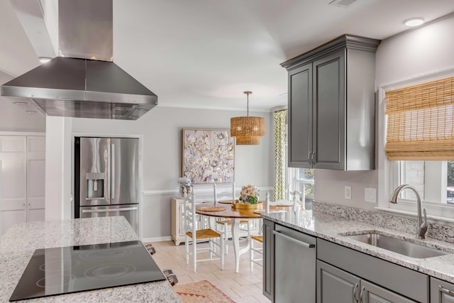 kitchen with appliances with stainless steel finishes, gray cabinetry, a sink, and island range hood