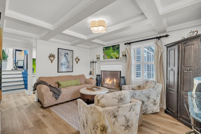 living room with light wood-style flooring, coffered ceiling, a fireplace, ornamental molding, and beamed ceiling