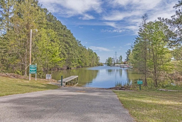 dock area with a water view and a lawn