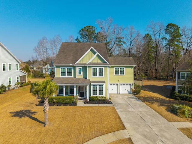 view of front of house with a garage, concrete driveway, board and batten siding, and a front yard