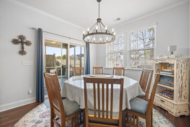 dining room with a notable chandelier, wood finished floors, visible vents, baseboards, and crown molding