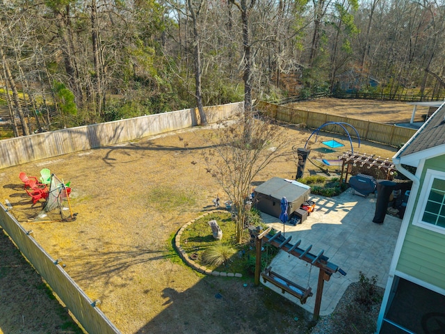 view of yard featuring a fenced backyard, a wooded view, and a patio