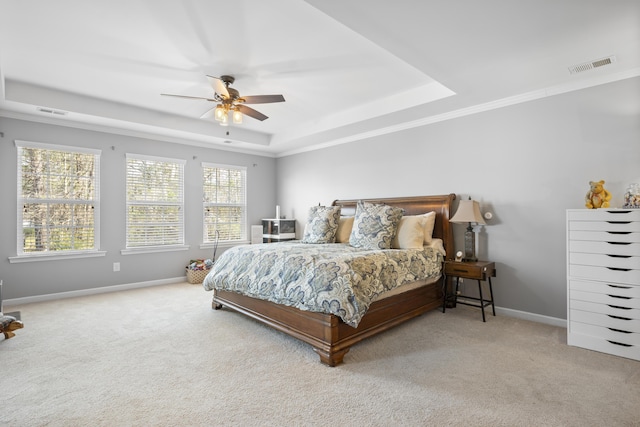 bedroom with baseboards, visible vents, a tray ceiling, and carpet flooring