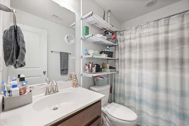 bathroom with toilet, curtained shower, visible vents, and vanity