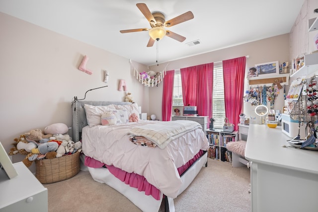 bedroom featuring visible vents, a ceiling fan, and light colored carpet