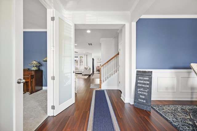 foyer entrance with stairs, visible vents, crown molding, and wood finished floors