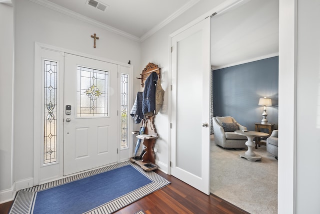 foyer featuring visible vents, crown molding, baseboards, and wood finished floors