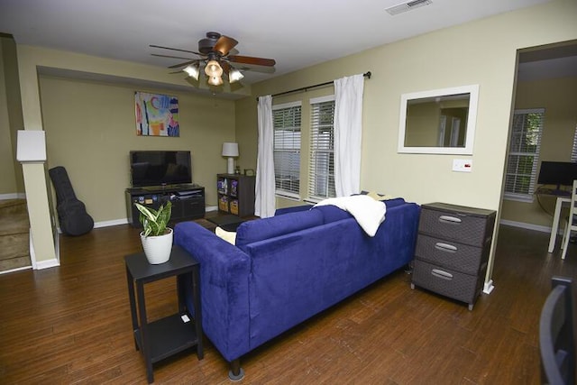 living room featuring dark wood-type flooring and ceiling fan