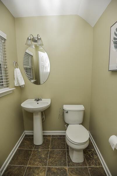 bathroom with lofted ceiling and toilet