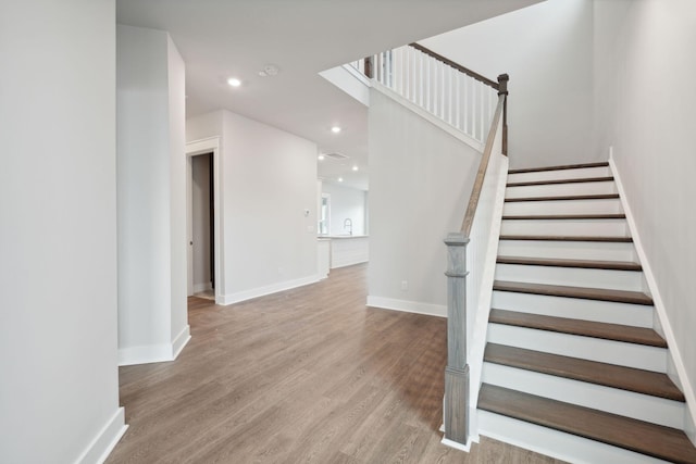 staircase with hardwood / wood-style floors