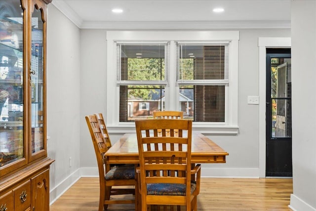 dining space featuring light hardwood / wood-style flooring and ornamental molding