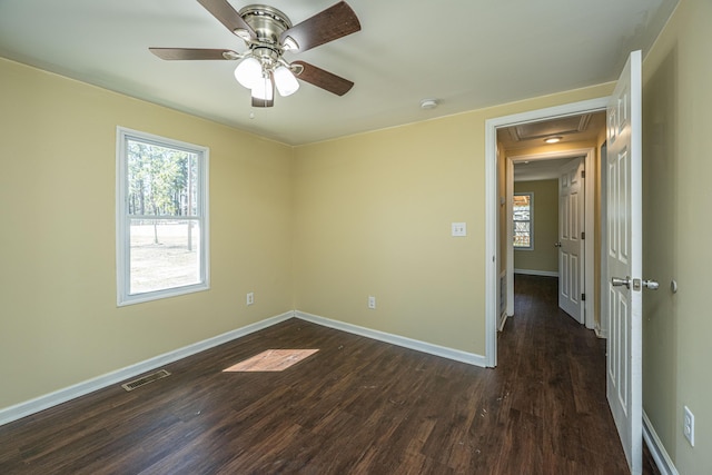 unfurnished bedroom featuring a ceiling fan, baseboards, visible vents, and dark wood-style flooring