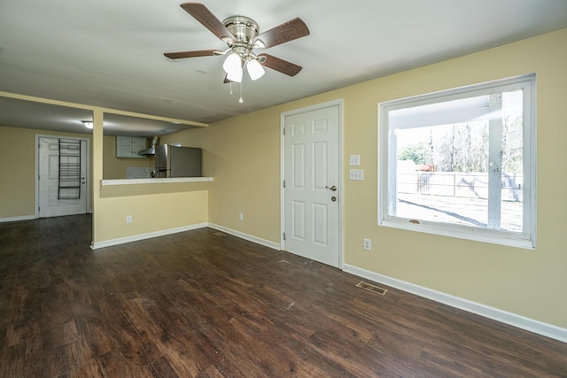 interior space with dark wood-style floors, visible vents, baseboards, and a ceiling fan