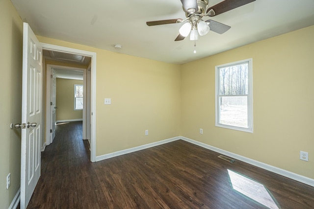 unfurnished room with visible vents, dark wood finished floors, baseboards, and ceiling fan