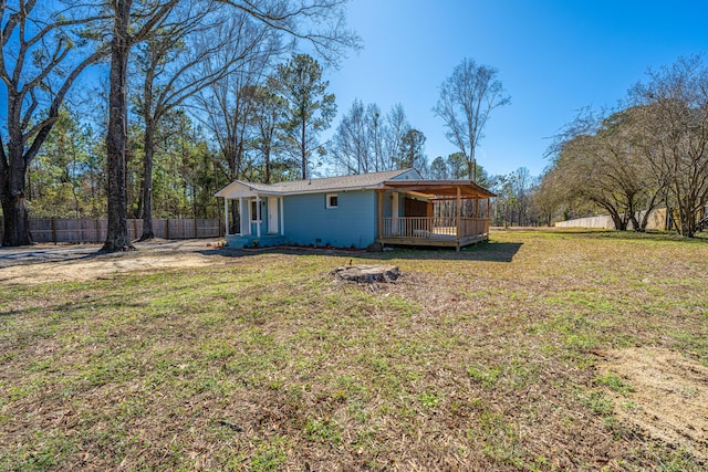 back of property featuring fence private yard, a deck, and a yard