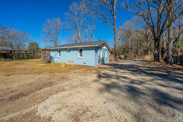 view of home's exterior featuring a yard, crawl space, fence, and driveway